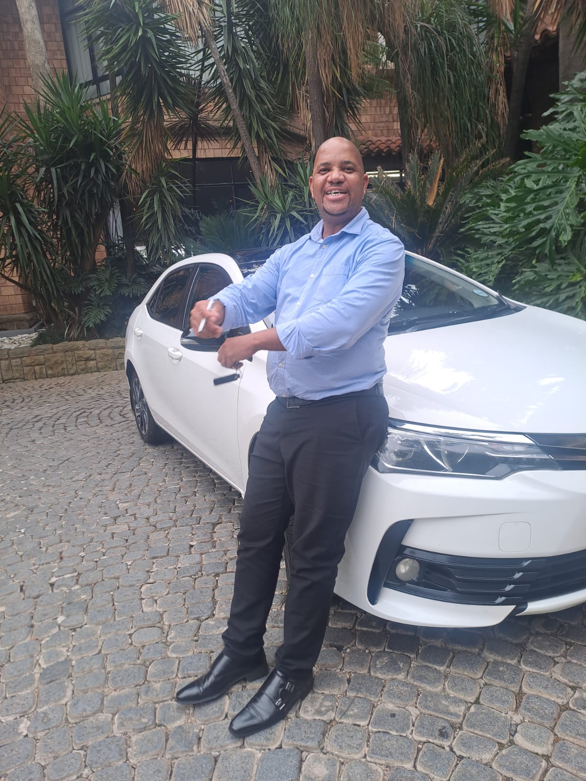 Thulamo driver next to company vehicle
